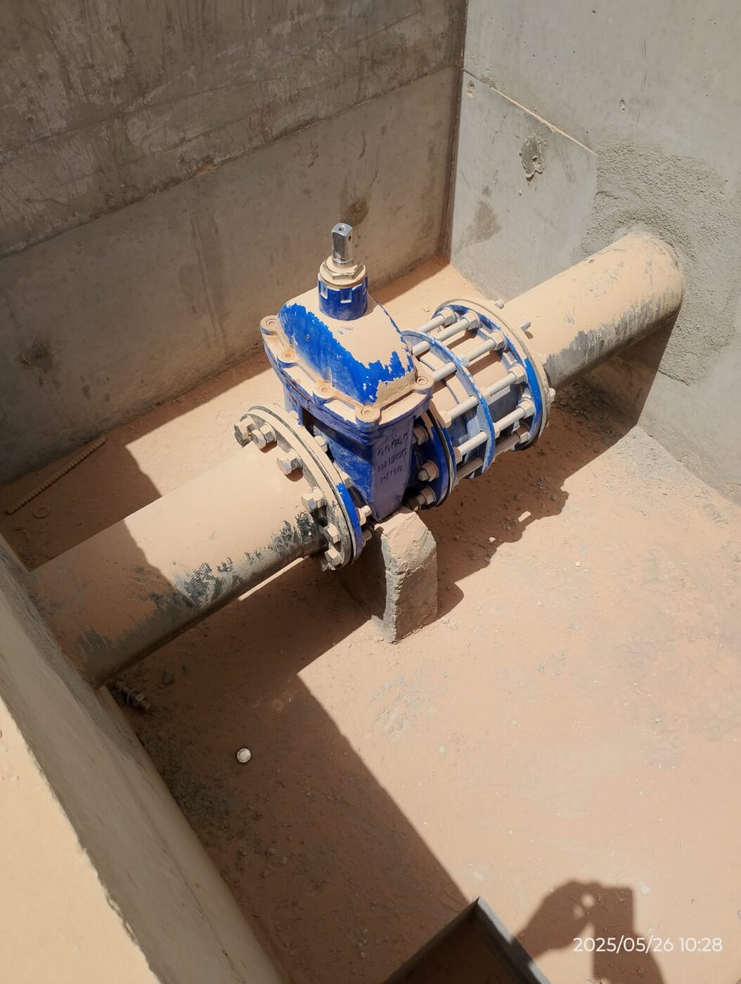 Gate valve and flange assembly inside concrete chamber